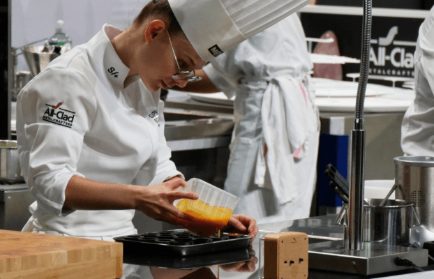 Jade Biaggini en train de remplir les moules silicone sur-mesure en forme de carotte pour le concours Bocuse d'or France 2023