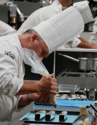 Edouard Loubet en train de remplir un moule silicone sur-mesure pour l'insert de la truite farcie présentée au Bocuse d'or 2023